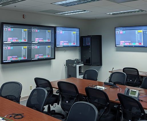 office with desks and monitors on the wall